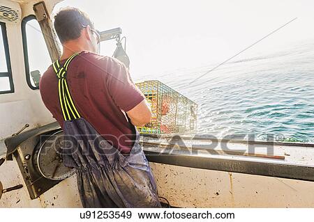 Stock Photo - Fisherman throwing lobster trap. Fotosearch