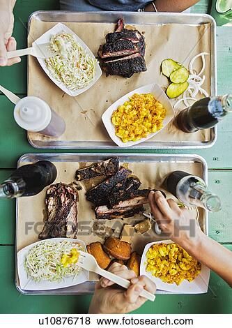 Stock Photo - Friends eating barbecue food. Fotosearch