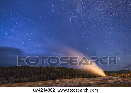 Stock Image - Geyser erupting at night. Fotosearch