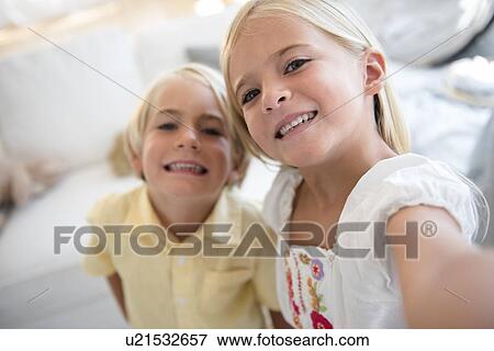 Girl (6-7) and boy (4-5) looking at camera View Large Photo Image Stock Photo - Girl (6-7) and boy (4-5) looking at camera. Fotosearch