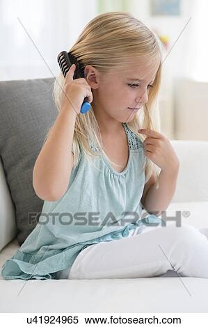 Girl (6-7) brushing hair View Large Photo Image Stock Photography - Girl (6-7) brushing hair. Fotosearch