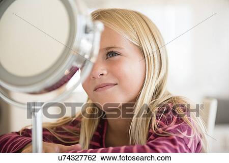 Girl (6-7) looking at vanity mirror View Large Photo Image Stock Image - Girl (6-7) looking at vanity mirror. Fotosearch