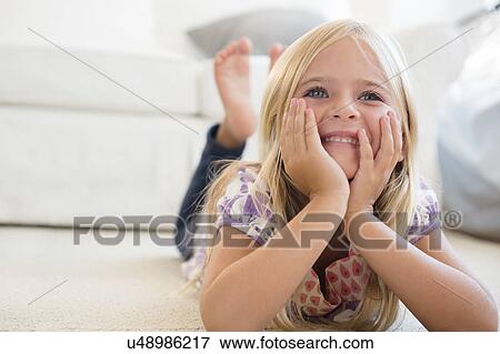 Girl (6-7) lying on floor View Large Photo Image Stock Photo - Girl (6-7) lying on floor. Fotosearch
