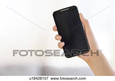 Hand holding smart phone View Large Photo Image Stock Photo - Hand holding smart phone. Fotosearch