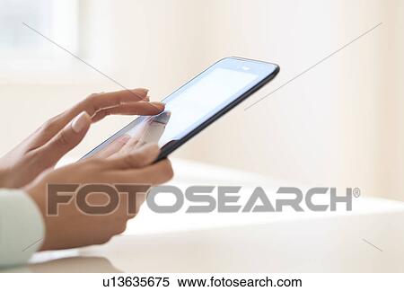 Stock Photography - Hands using tablet pc. Fotosearch