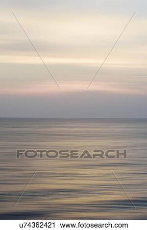 Stock Image - Horizon over water at dusk. Fotosearch