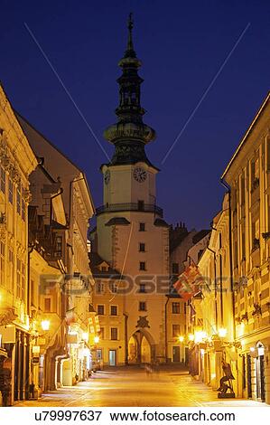 Stock Photo - Illuminated alley and tower at night. Fotosearch