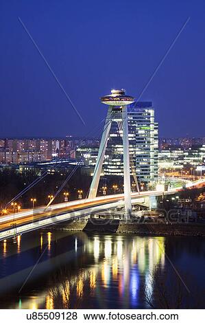 Illuminated bridge over river at night View Large Photo Image Stock Photo - Illuminated bridge over river at night. Fotosearch