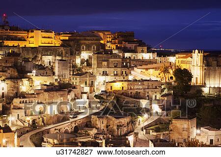 Illuminated city buildings at dusk View Large Photo Image Stock Photo - Illuminated city buildings at dusk. Fotosearch