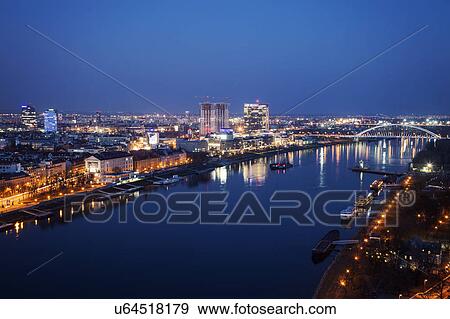 Stock Photo - Illuminated cityscape and river at night. Fotosearch