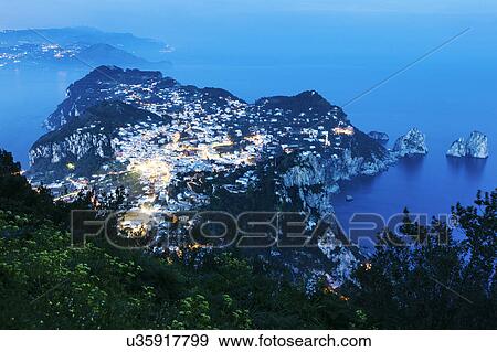 Stock Photo - Illuminated cityscape on island at dusk. Fotosearch
