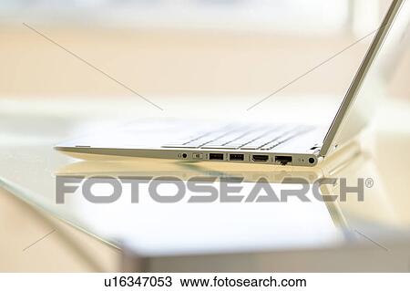 Stock Image - Laptop on glass table. Fotosearch