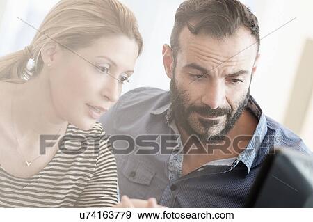 Man and woman looking at computer View Large Photo Image Stock Photo - Man and woman looking at computer. Fotosearch