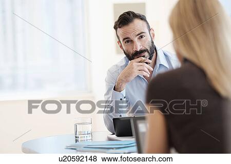 Stock Photo - Man and woman sitting in office. Fotosearch