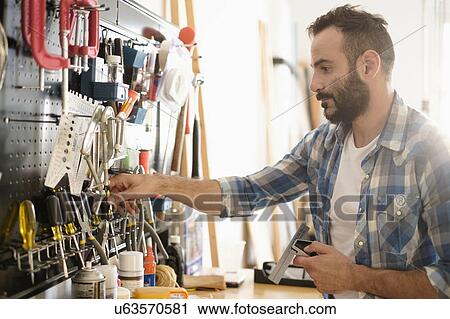 Man choosing tools in workshop View Large Photo Image Stock Image - Man choosing tools in workshop. Fotosearch