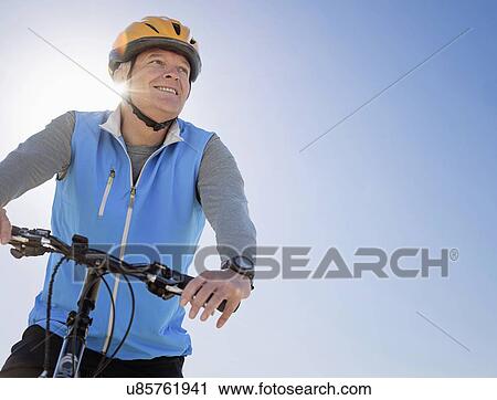 Man in cycling helmet on bike outdoors View Large Photo Image Stock Image - Man in cycling helmet on bike outdoors. Fotosearch