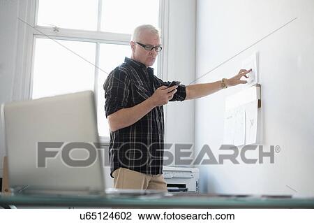Man in office using smartphone View Large Photo Image Stock Image - Man in office using smartphone. Fotosearch
