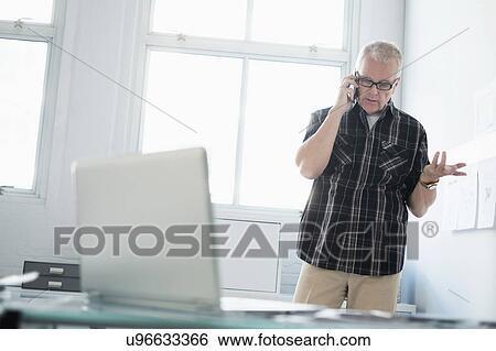 Man in office using smartphone View Large Photo Image Stock Photograph - Man in office using smartphone. Fotosearch