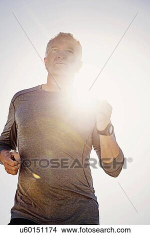 Picture - Man jogging outdoors. Fotosearch