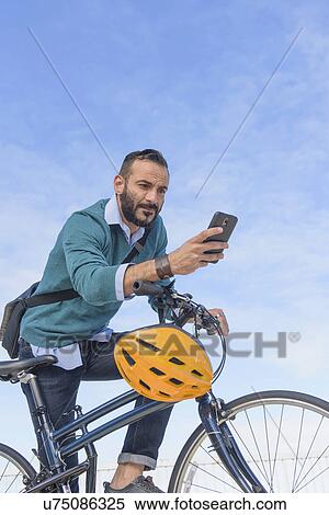 Man with bike using phone View Large Photo Image Stock Photography - Man with bike using phone. Fotosearch