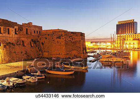 Stock Photograph - Marina and Castello Angiono at sunrise. Fotosearch