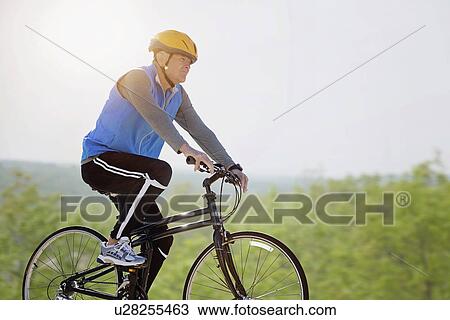 Mature man riding bicycle View Large Photo Image Stock Image - Mature man riding bicycle. Fotosearch
