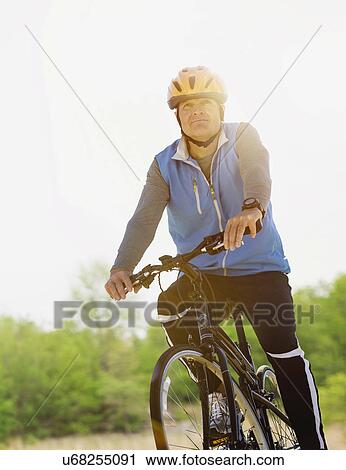 Mature man riding bicycle View Large Photo Image Stock Image - Mature man riding bicycle. Fotosearch