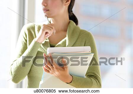 Mid section of business woman holding documents View Large Photo Image Stock Photography - Mid section of business woman holding documents. Fotosearch