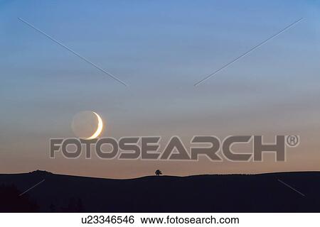 Stock Photograph - Moon on sky at sunset. Fotosearch