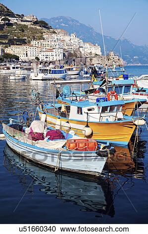 Stock Image - Moored fishing boats with town in background. Fotosearch