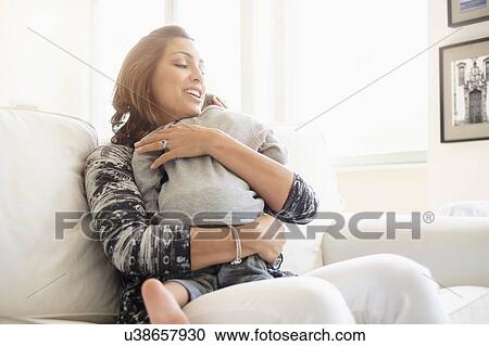Mother embracing son (2-3) on sofa View Large Photo Image Stock Image - Mother embracing son (2-3) on sofa. Fotosearch