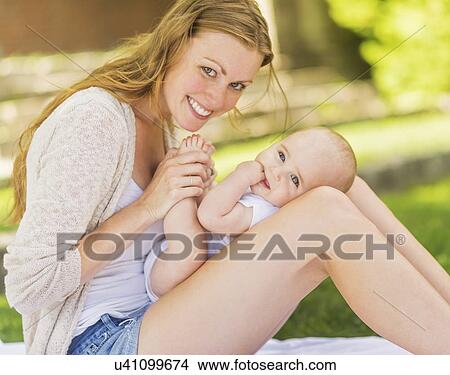 Mother holding baby (6-11 months) on lap View Large Photo Image Picture - Mother holding baby (6-11 months) on lap. Fotosearch