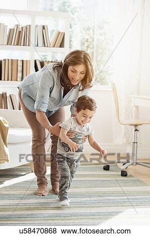 Mother holding son (2-3) making first steps View Large Photo Image Stock Photo - Mother holding son (2-3) making first steps. Fotosearch