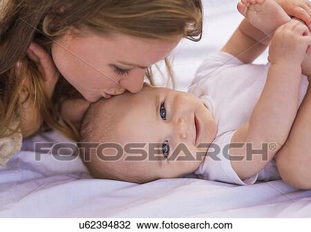 Mother kissing baby (6-11 months) View Large Photo Image Stock Image - Mother kissing baby (6-11 months). Fotosearch