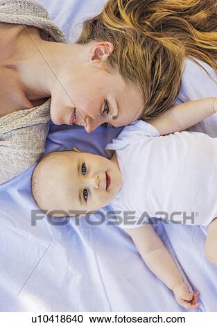 Mother lying down with baby boy (6-11 months) View Large Photo Image Stock Image - Mother lying down with baby boy (6-11 months). Fotosearch