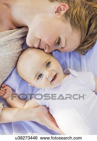 Mother lying down with baby boy (6-11 months) View Large Photo Image Stock Photograph - Mother lying down with baby boy (6-11 months). Fotosearch