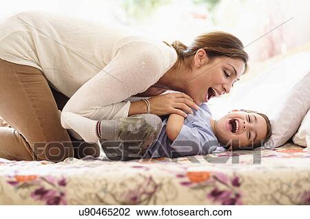 Mother playing with son (2-3) on bed View Large Photo Image Stock Image - Mother playing with son (2-3) on bed. Fotosearch