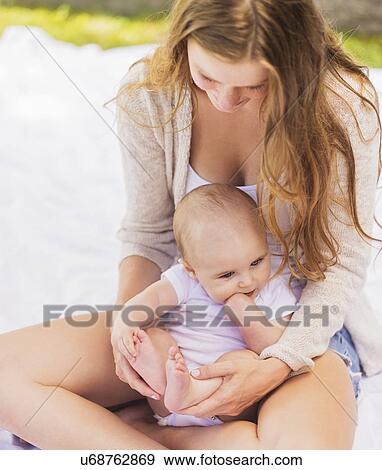 Mother sitting with baby boy (6-11 months) View Large Photo Image Stock Photo - Mother sitting with baby boy (6-11 months). Fotosearch