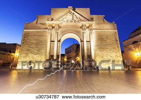 Stock Photo -  Porta Napoli illuminated at dusk. Fotosearch
