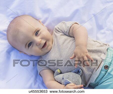 Portrait of baby boy (6-11 months) lying down View Large Photo Image Stock Image - Portrait of baby boy (6-11 months) lying down. Fotosearch