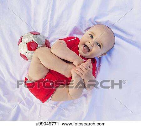 Portrait of baby boy (6-11 months) lying down with soccer ball View Large Photo Image Stock Image - Portrait of baby boy (6-11 months) lying down with soccer ball. Fotosearch