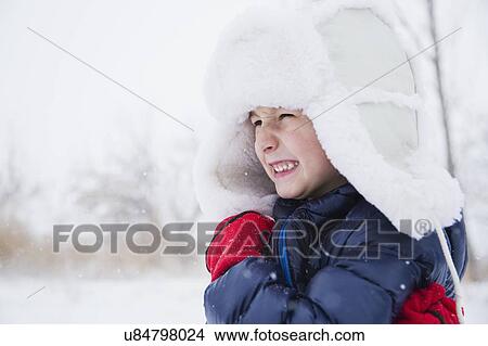 Picture - Portrait of boy (6-7) in fur hat and gloves. Fotosearch