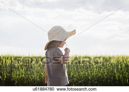 Stock Image - Portrait of girl in straw hat. Fotosearch