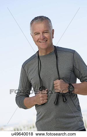Stock Photo - Portrait of man in sports clothing with jump rope. Fotosearch
