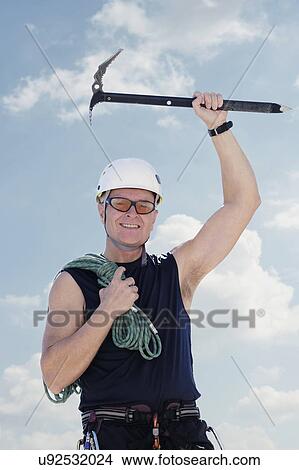 Picture - Portrait of man with climbing equipment outdoors. Fotosearch