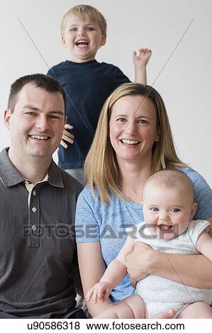 Stock Photo - Portrait of parents with son (2-3) and baby daughter (12-17 months). Fotosearch