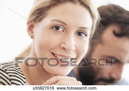 Portrait of smiling woman with man in background View Large Photo Image Stock Photograph - Portrait of smiling woman with man in background. Fotosearch