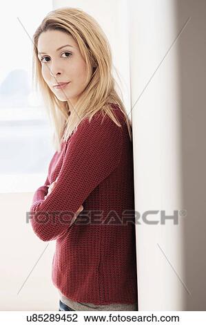 Stock Image - Portrait of young woman looking at camera. Fotosearch