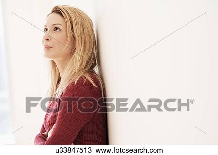 Stock Image - Portrait of young woman looking up. Fotosearch