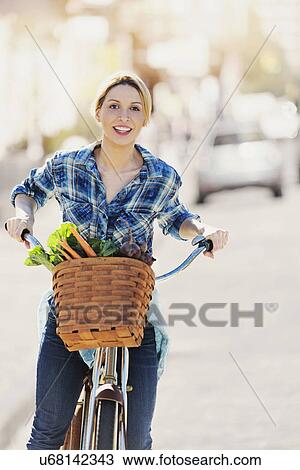 Portrait of young woman standing with bicycle View Large Photo Image Stock Image - Portrait of young woman standing with bicycle. Fotosearch